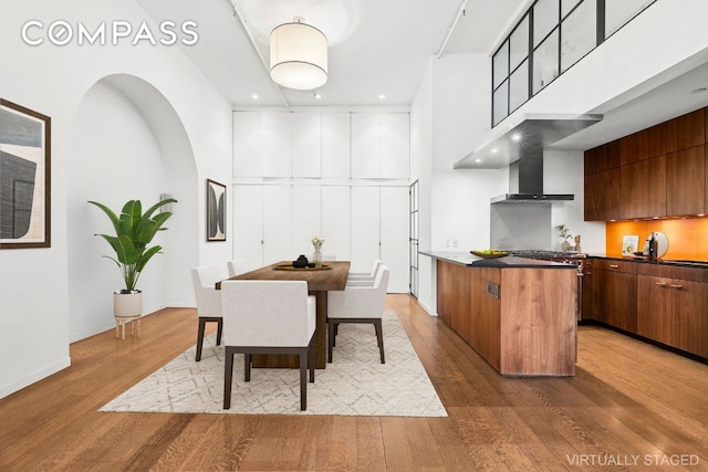 dining room featuring hardwood / wood-style flooring and a towering ceiling