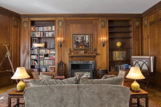 living room featuring built in shelves, a fireplace, and wood walls