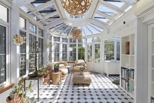 sunroom with french doors, a skylight, a wall mounted air conditioner, a sink, and a high ceiling