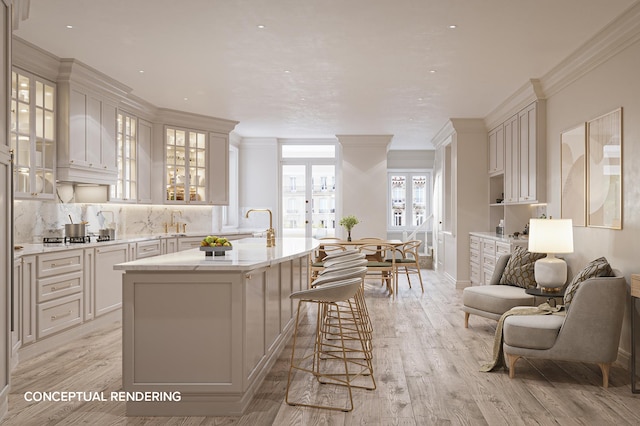 kitchen featuring crown molding, a kitchen breakfast bar, an island with sink, open floor plan, and glass insert cabinets