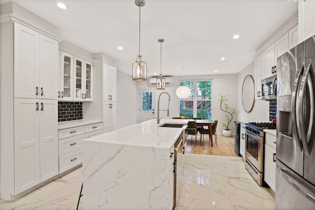 kitchen with a kitchen island with sink, recessed lighting, white cabinetry, marble finish floor, and appliances with stainless steel finishes