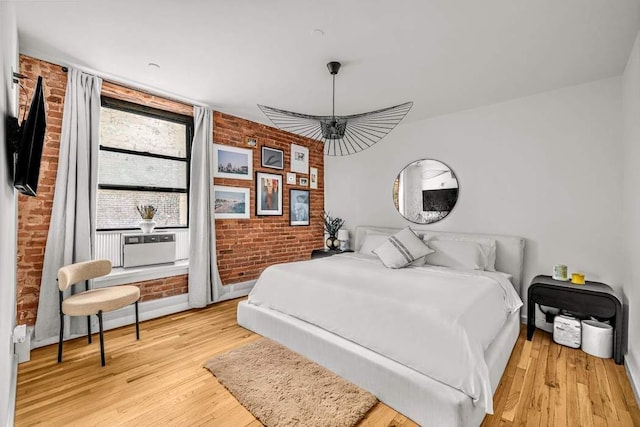 264 Water St Unit 5B, New York City, NY 10038 - bedroom with light wood-style flooring, brick wall, baseboards, and a ceiling fan