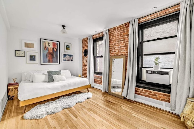 264 Water St Unit 5B, New York City, NY 10038 - bedroom featuring brick wall, access to outside, cooling unit, and hardwood / wood-style flooring