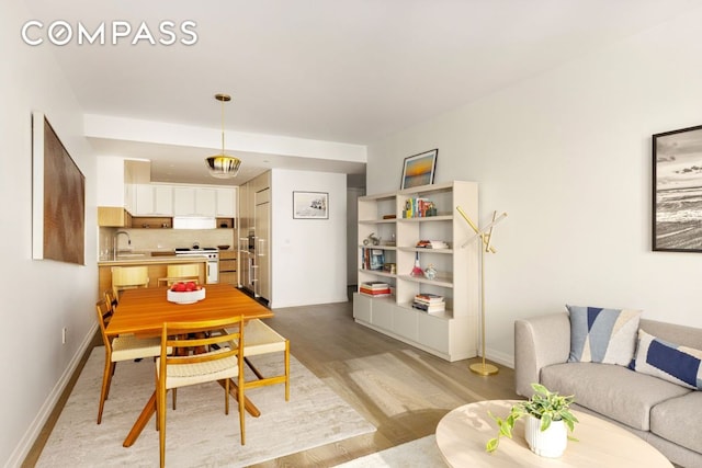 dining area featuring baseboards and light wood finished floors