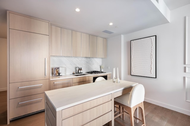 500 W 45th St Unit 207, New York City, NY 10036 - kitchen with a sink, wood finished floors, light countertops, light brown cabinetry, and recessed lighting