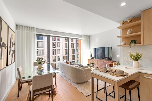 living area featuring light wood-style floors, healthy amount of natural light, and recessed lighting