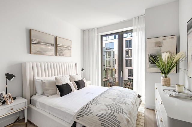 bedroom featuring light wood-type flooring and access to outside