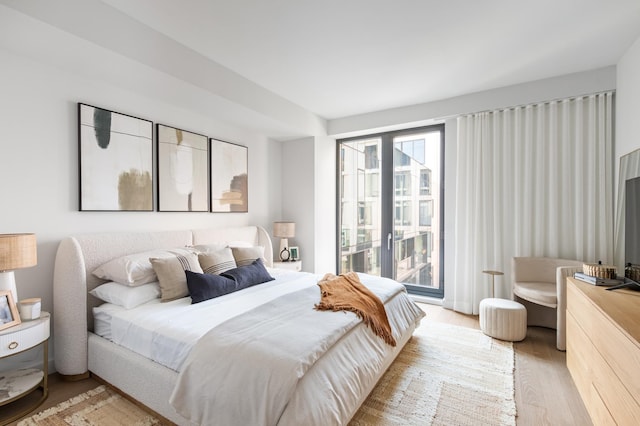 bedroom featuring wood finished floors and access to outside