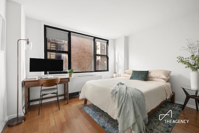 bedroom with baseboards and wood finished floors