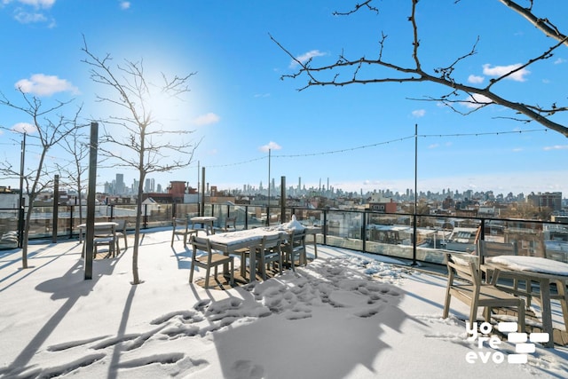 snow covered patio with a city view