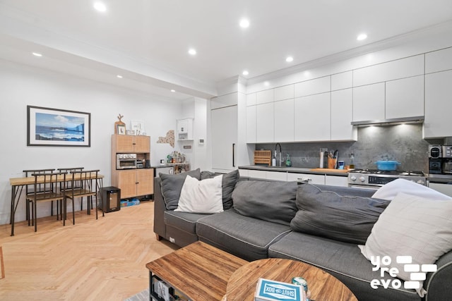 living area featuring ornamental molding and recessed lighting