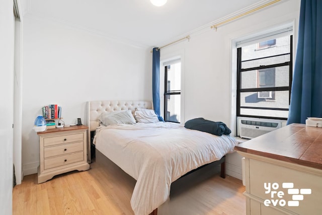 bedroom featuring light wood-style floors and ornamental molding