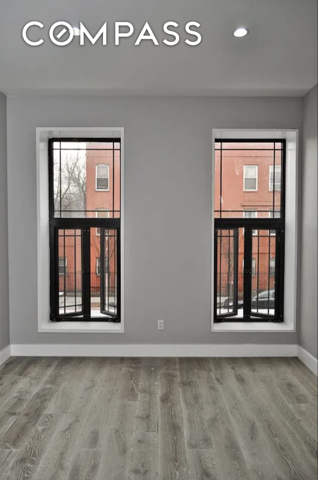 unfurnished room featuring recessed lighting, baseboards, and wood finished floors