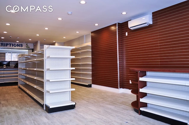 spacious closet with wood finished floors and a wall mounted AC