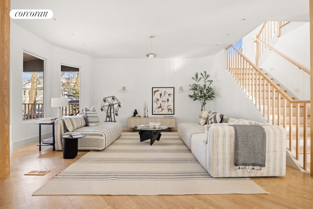 living room with stairway, wood finished floors, and visible vents