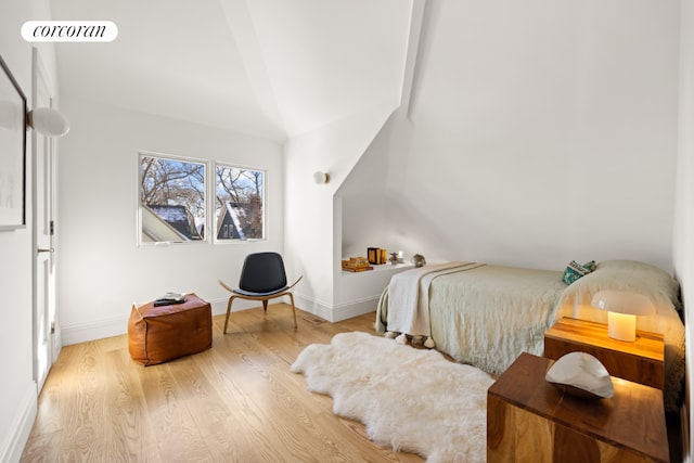 bedroom with light wood-type flooring and lofted ceiling