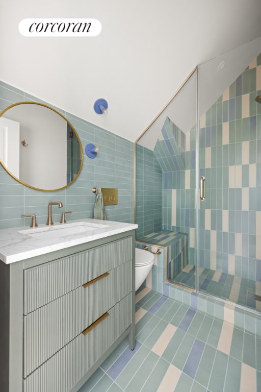 bathroom with tile patterned floors, vanity, tile walls, and toilet