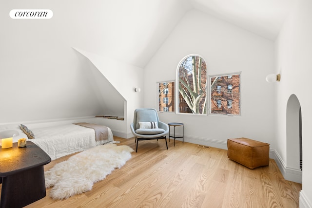 bedroom featuring light hardwood / wood-style floors and high vaulted ceiling