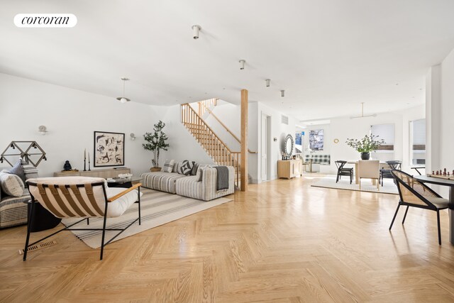 living area featuring visible vents and stairway