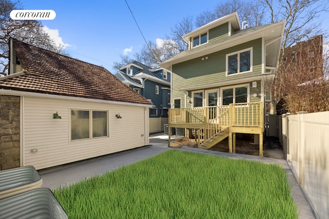 rear view of property featuring a yard and a deck