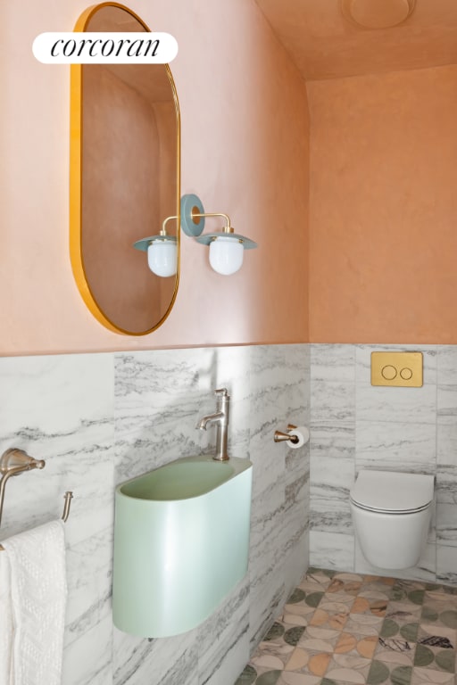 bathroom featuring toilet and tile walls