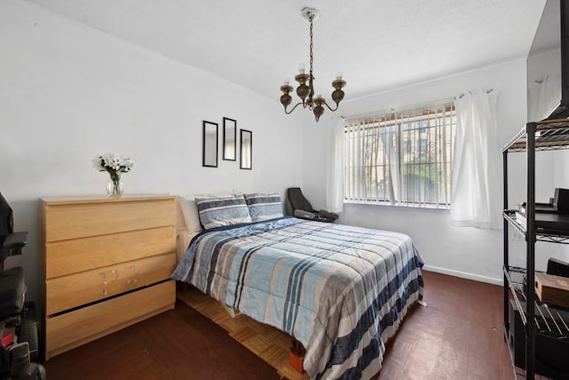 bedroom with a chandelier and baseboards