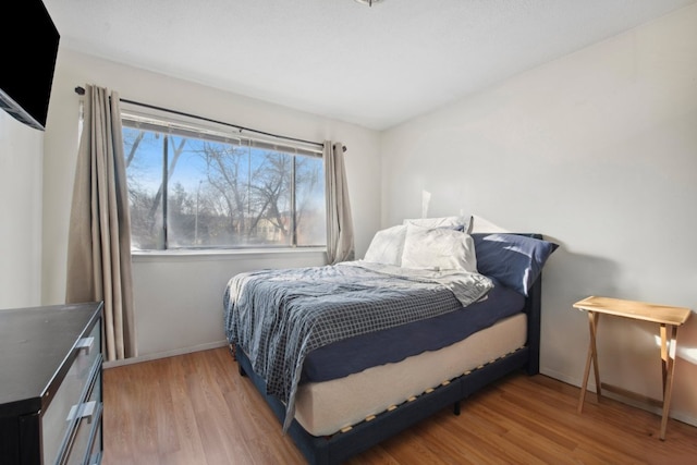 bedroom featuring wood finished floors and baseboards