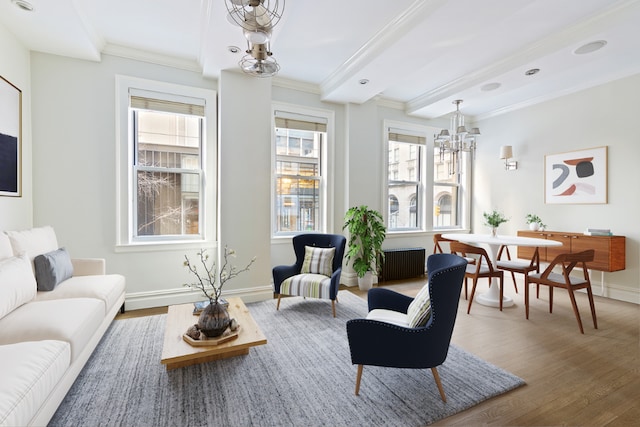 living area featuring baseboards, wood finished floors, and crown molding