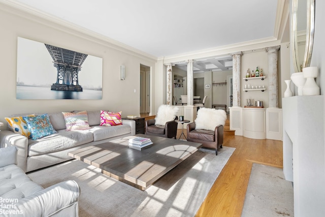 living room featuring ornamental molding, light hardwood / wood-style floors, and ornate columns