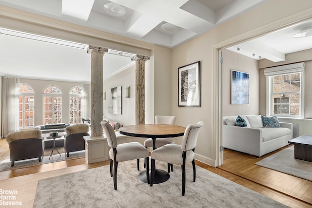 dining area with decorative columns, coffered ceiling, light hardwood / wood-style floors, and beam ceiling