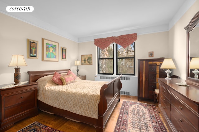 bedroom with ornamental molding, visible vents, and radiator heating unit