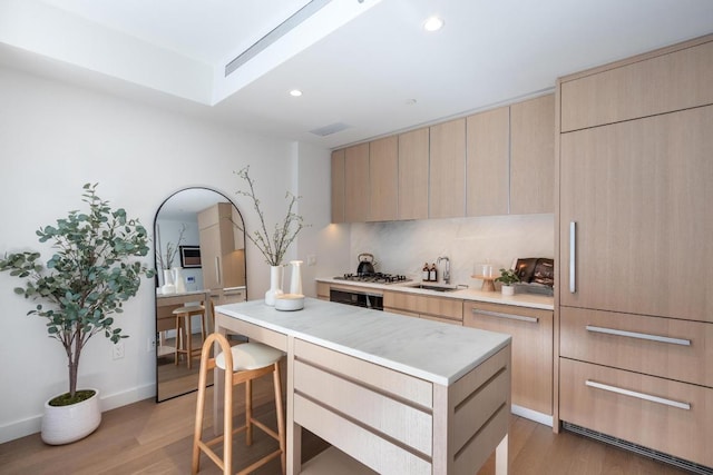 kitchen featuring a kitchen bar, light brown cabinets, and a center island