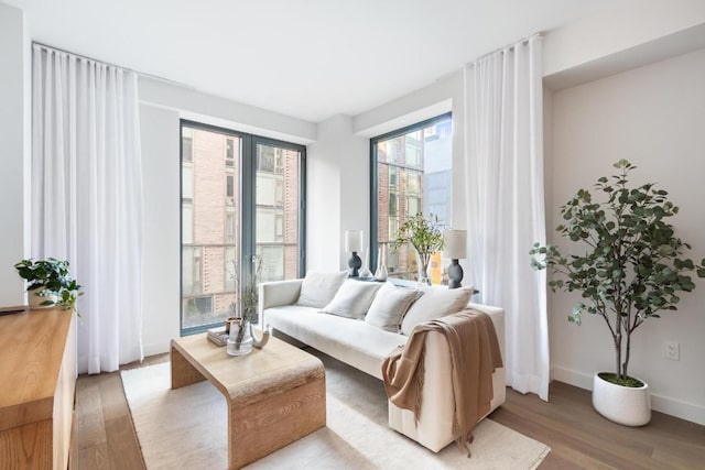 living area featuring light wood-style flooring and baseboards