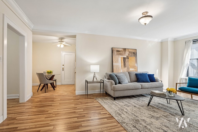 living area with a ceiling fan, baseboards, light wood-style floors, and crown molding