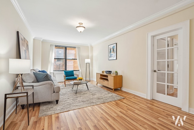 living area featuring a ceiling fan, crown molding, light wood-style floors, and baseboards