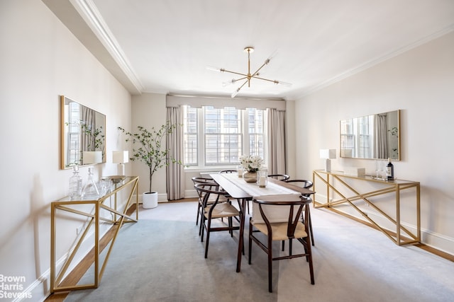 dining space with ornamental molding, light carpet, a notable chandelier, and baseboards