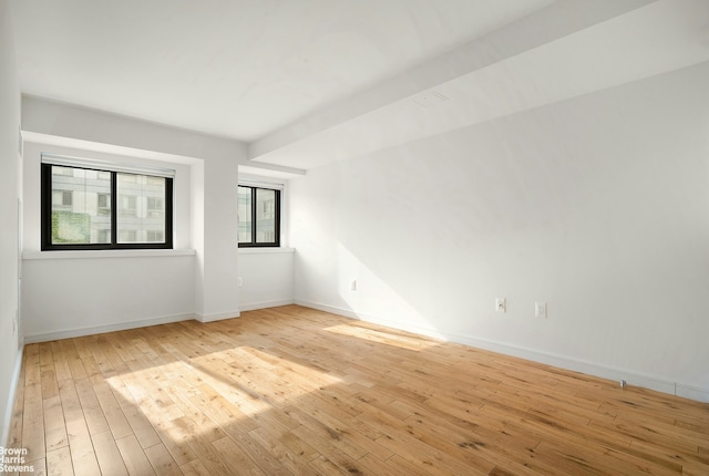 empty room featuring light wood-style flooring and baseboards