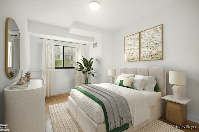 bedroom with light wood-style flooring, visible vents, and baseboards