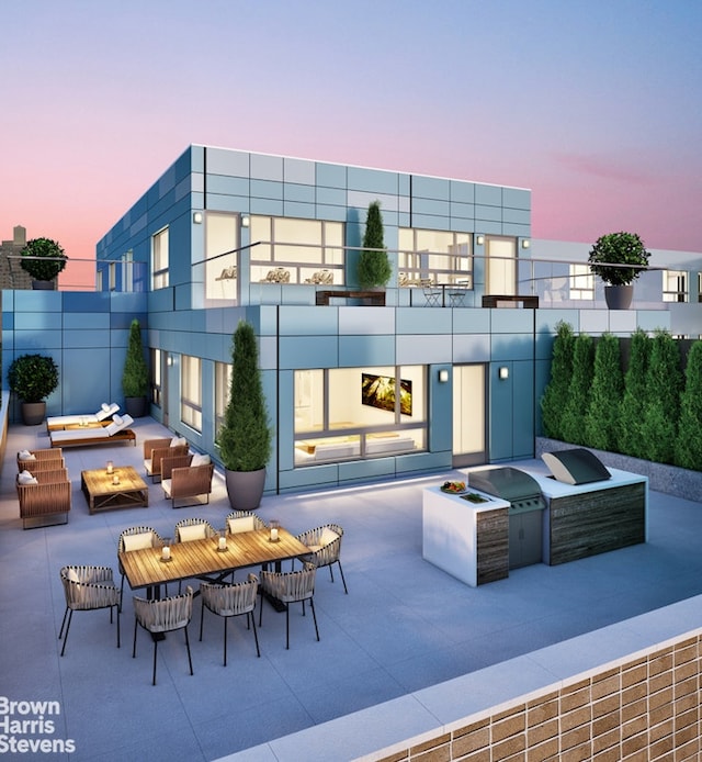 patio terrace at dusk featuring exterior bar, an outdoor living space with a fire pit, and area for grilling