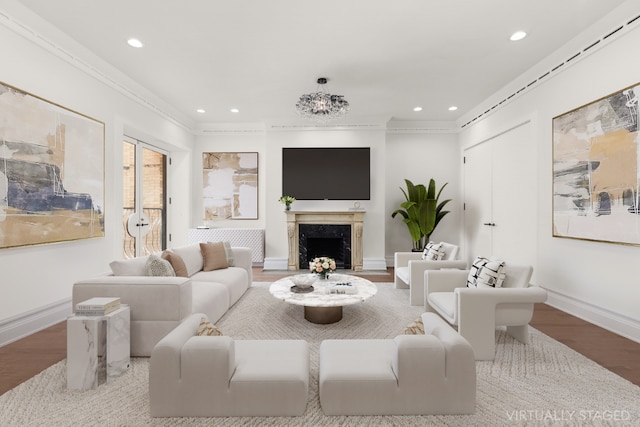 living room with hardwood / wood-style flooring, crown molding, and a fireplace