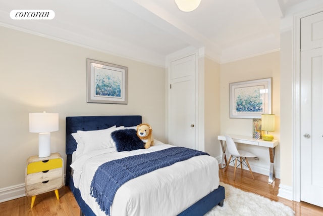 bedroom with crown molding and wood-type flooring