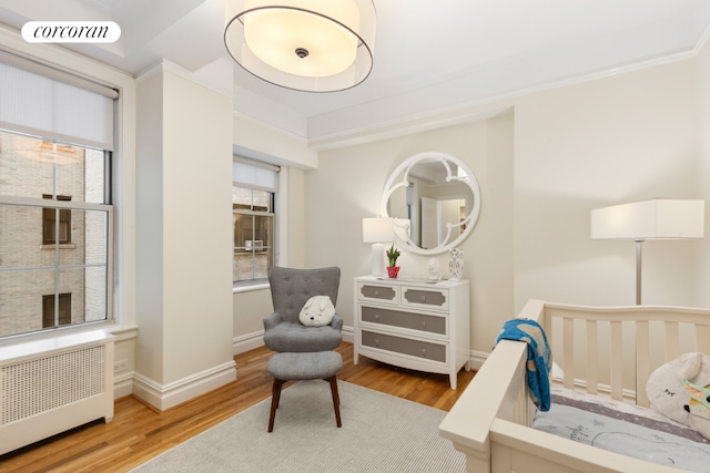 bedroom featuring radiator heating unit and light wood-type flooring