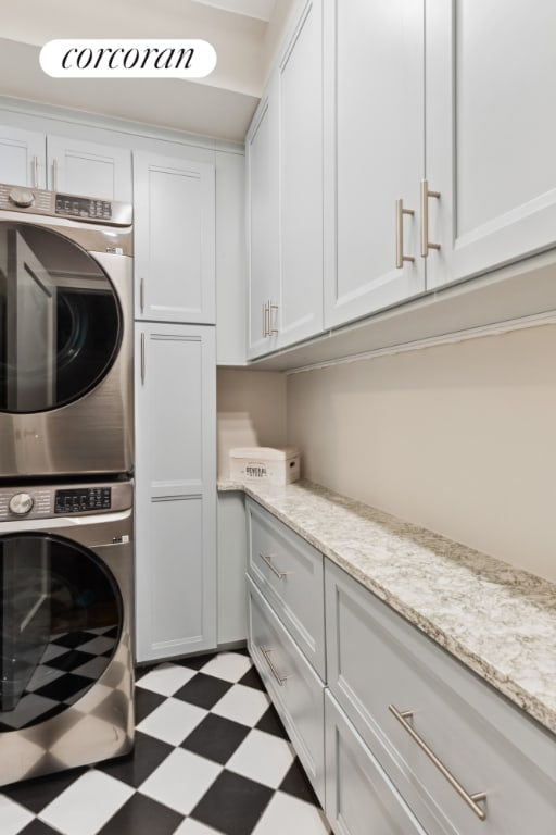 laundry area featuring cabinets and stacked washer and dryer