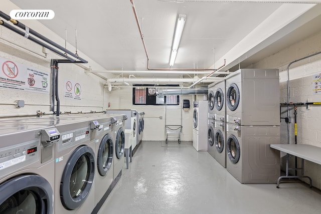 shared laundry area featuring stacked washer / dryer, concrete block wall, and separate washer and dryer