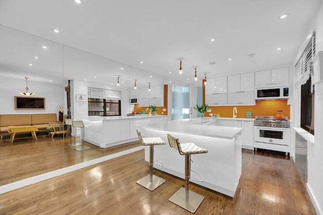 living room with a spacious island, white cabinetry, and a kitchen bar