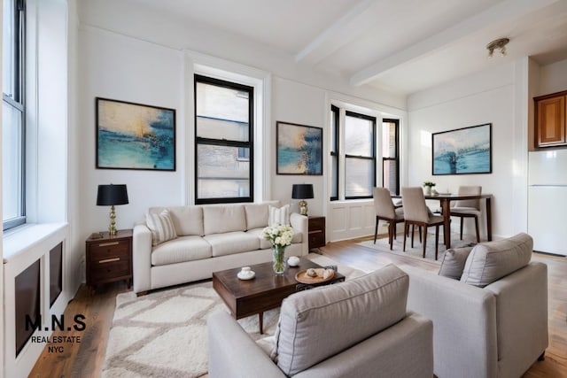 living room featuring beamed ceiling and wood finished floors