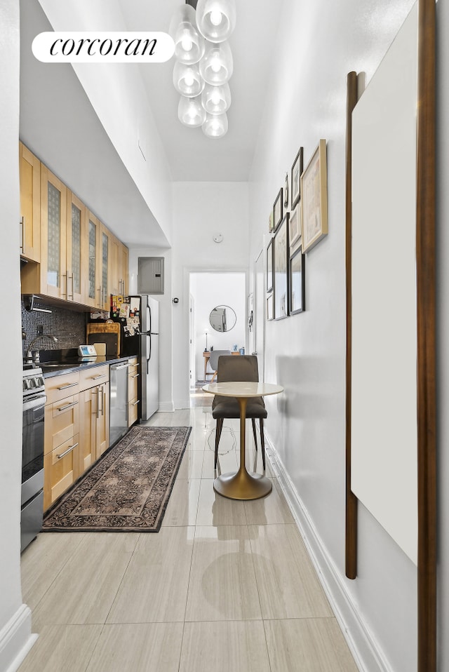 interior space featuring light tile patterned floors, a sink, and baseboards