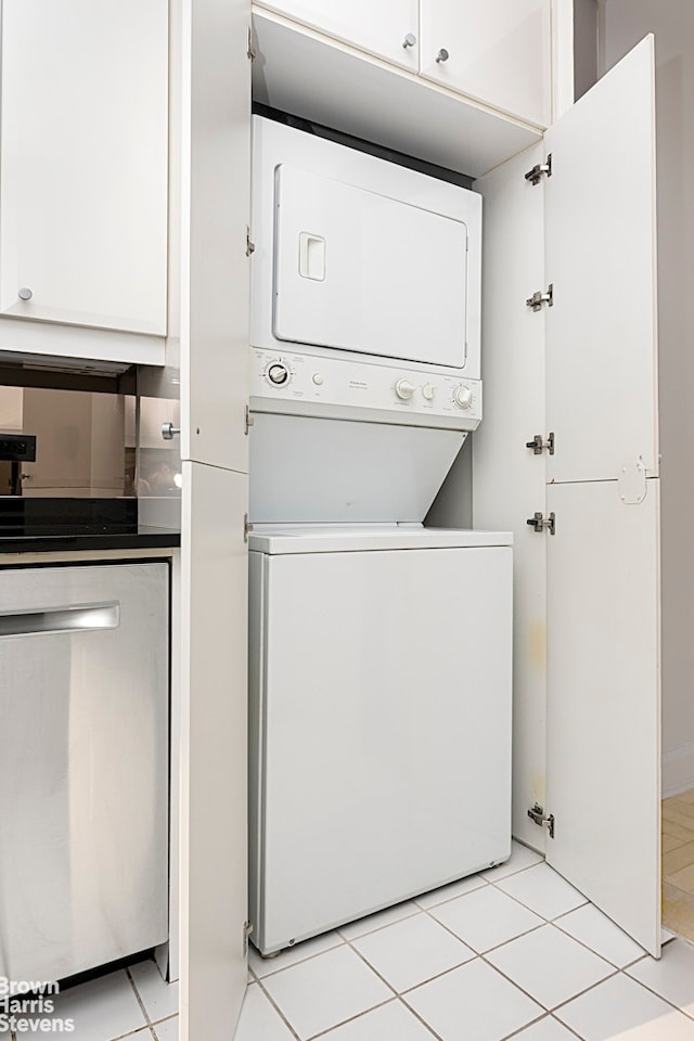 laundry area with stacked washer / dryer and light tile patterned floors