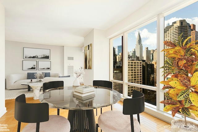 dining room featuring a wealth of natural light, visible vents, and a view of city