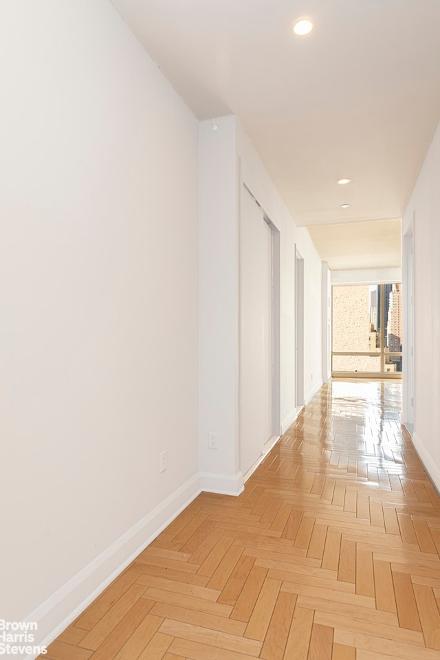 hallway with recessed lighting and baseboards